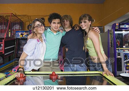 Teenagers posing at game in arcade View Large Photo Image Stock Image - Teenagers posing at game in arcade. Fotosearch