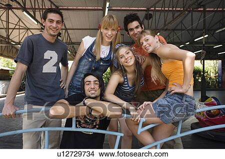 Picture - Teenagers posing for a picture in amusement park. Fotosearch