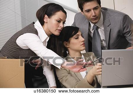 Stock Image - Three business people in office. Fotosearch