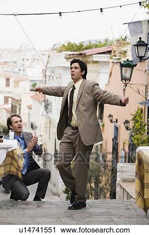 Stock Image - Two businessmen Greek dancing. Fotosearch