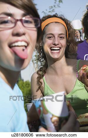 Stock Photograph - Two female teenagers, one with tongue ring. Fotosearch