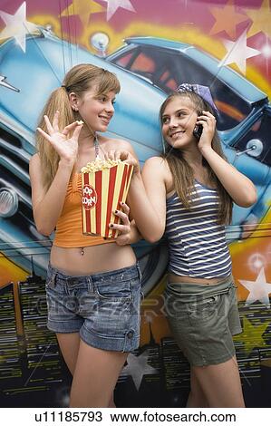 Two female teenagers posing in amusement park View Large Photo Image Stock Image - Two female teenagers posing in amusement park. Fotosearch