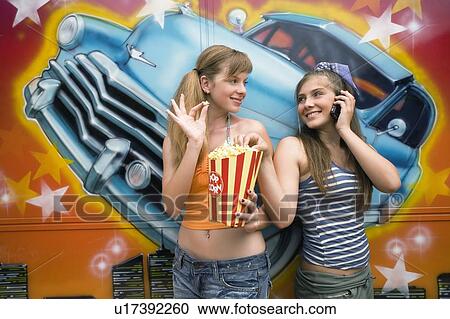 Two female teenagers posing in amusement park View Large Photo Image Stock Image - Two female teenagers posing in amusement park. Fotosearch