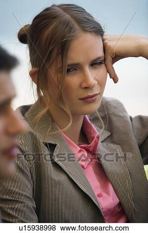Stock Photo - Woman leaning into her hand at a meeting. Fotosearch