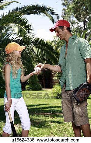 Stock Photograph - Father and daughter with baseball outfit. Fotosearch