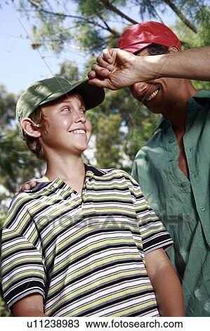 Stock Image - Father and son with baseball caps. Fotosearch