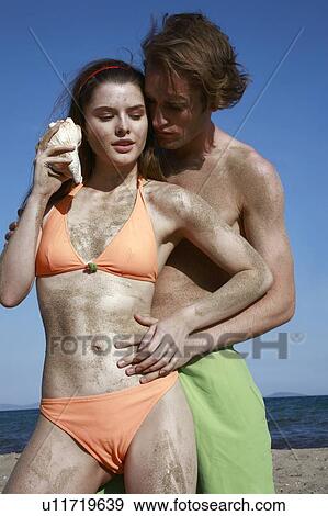 Female young adult with seashell and male young adult View Large Photo Image Stock Photo - Female young adult with seashell and male young adult. Fotosearch