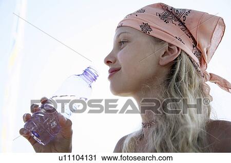Stock Image - Girl drinking water from a bottle. Fotosearch