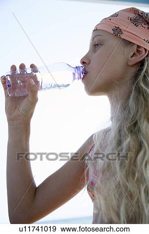 Stock Photo - Girl drinking water from a bottle. Fotosearch