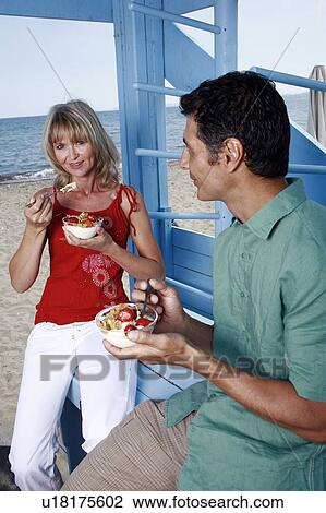 Mature adult couple eating breakfast at beach View Large Photo Image Stock Image - Mature adult couple eating breakfast at beach. Fotosearch