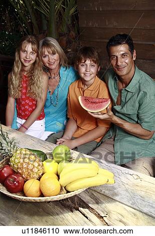 Stock Image - Parents with children and fruit. Fotosearch