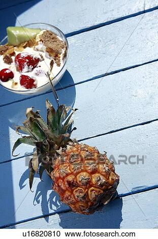 Stock Image - Pineapple and bowl of yogurt and fruit. Fotosearch