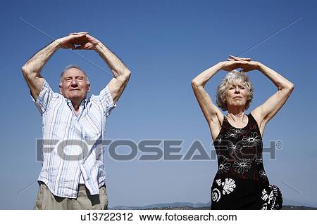 Senior couple stretching on beach View Large Photo Image Stock Image - Senior couple stretching on beach. Fotosearch