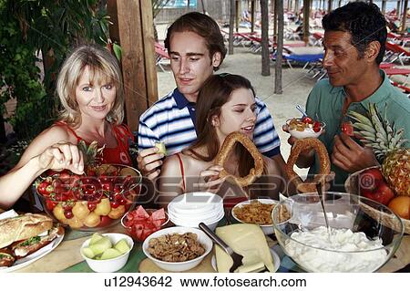 Young adult couple and parents eating breakfast View Large Photo Image Stock Image - Young adult couple and parents eating breakfast. Fotosearch