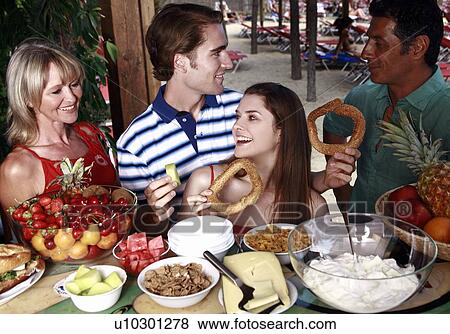 Young adult couple and parents eating breakfast View Large Photo Image Stock Photo - Young adult couple and parents eating breakfast. Fotosearch