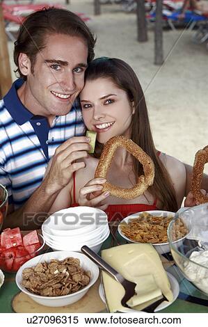 Young adult couple at breakfast holding sesame bread ring and melon View Large Photo Image Stock Photography - Young adult couple at breakfast holding sesame bread ring and melon. Fotosearch