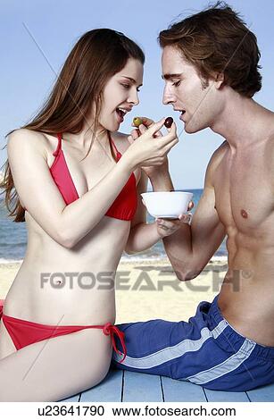 Young adult couple feeding each other View Large Photo Image Stock Image - Young adult couple feeding each other. Fotosearch