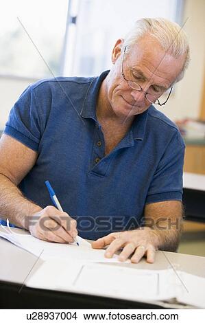 Picture - Adult student in class taking notes. Fotosearch