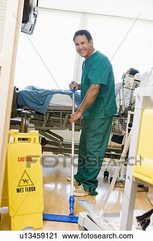 Stock Image - An Orderly Mopping The Floor In A Hospital Ward. Fotosearch