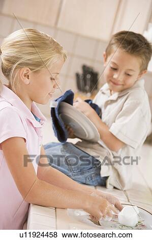 Stock Photo - Brother And Sister Cleaning Dishes Together . Fotosearch