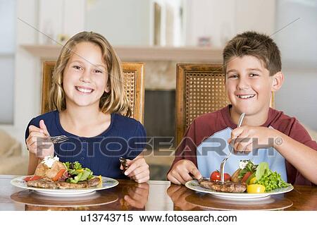 Stock Photography - Brother And Sister Eating meal, mealtime Together . Fotosearch