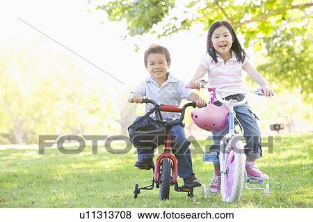 Brother and sister outdoors on bicycles smiling View Large Photo Image Stock Photo - Brother and sister outdoors on bicycles smiling. Fotosearch