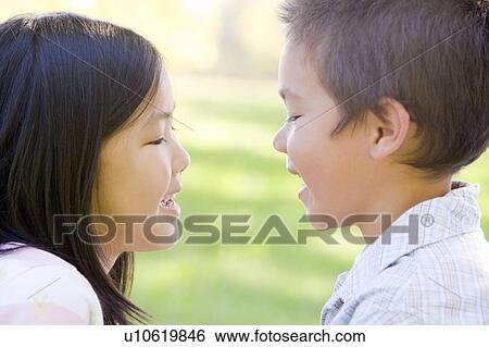 Brother and sister outdoors staring at each other and smiling View Large Photo Image Stock Photograph - Brother and sister outdoors staring at each other and smiling. Fotosearch