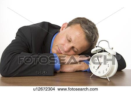 Businessman Asleep On Desk By An Alarm Clock View Large Photo Image Picture - Businessman Asleep On Desk By An Alarm Clock . Fotosearch