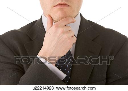 Stock Image - Businessman Holding His Hand Up To His Chin. Fotosearch
