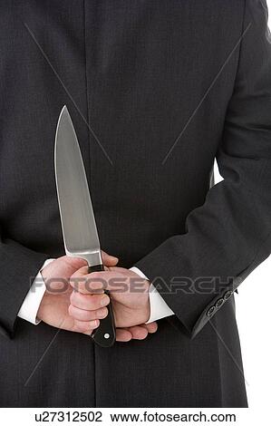 Stock Image - Businessman Holding Knife Behind His Back. Fotosearch