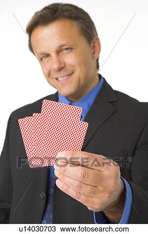 Stock Image - Businessman Holding Playing Cards. Fotosearch