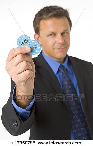 Stock Photo - Businessman Holding Poker Chips To The Value Of $2000. Fotosearch