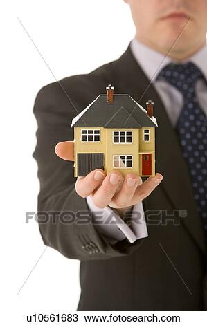 Stock Image - Businessman Holding Small House . Fotosearch