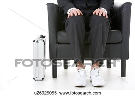Stock Photography - Businessman Holding Wearing Sneakers . Fotosearch