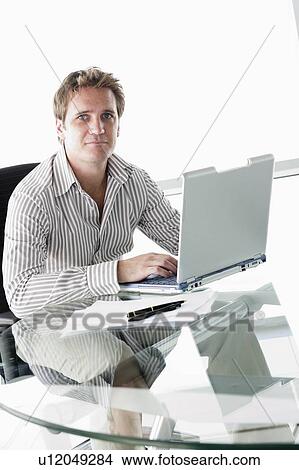 Businessman in boardroom with laptop View Large Photo Image Picture - Businessman in boardroom with laptop. Fotosearch