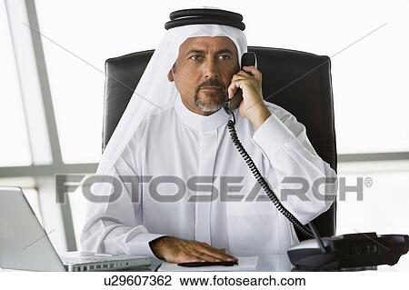 Businessman in office on telephone by laptop (high key/selective focus) View Large Photo Image Stock Image - Businessman in office on telephone by laptop (high key/selective focus). Fotosearch