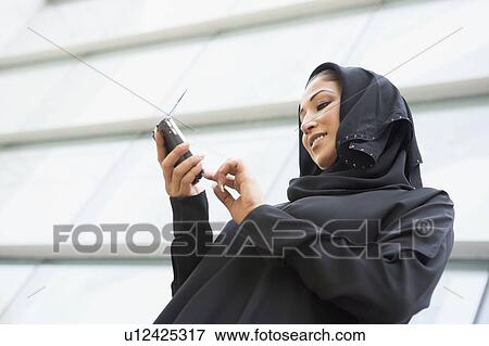 Businessman outdoors by building using PDA View Large Photo Image Stock Photo - Businessman outdoors by building using PDA. Fotosearch
