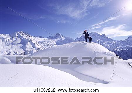 Businessman outdoors on snowy mountain using cellular phone View Large Photo Image Stock Image - Businessman outdoors on snowy mountain using cellular phone. Fotosearch