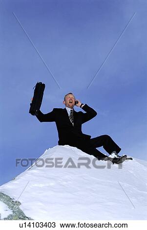 Businessman outdoors on snowy mountain using cellular phone and yelling View Large Photo Image Stock Image - Businessman outdoors on snowy mountain using cellular phone and yelling. Fotosearch