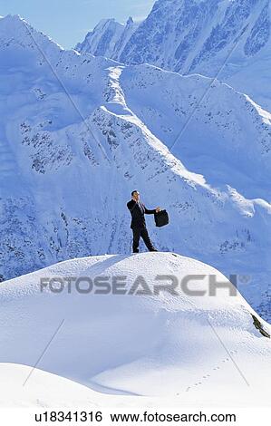 Businessman outdoors on snowy mountain using cellular phone View Large Photo Image Stock Photograph - Businessman outdoors on snowy mountain using cellular phone. Fotosearch