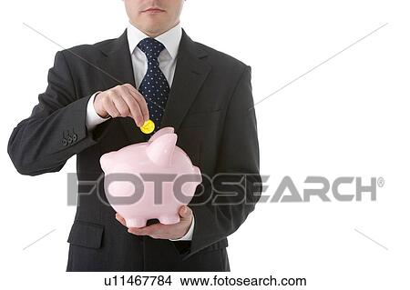 Businessman Putting Coin Into Piggy Bank View Large Photo Image Picture - Businessman Putting Coin Into Piggy Bank. Fotosearch