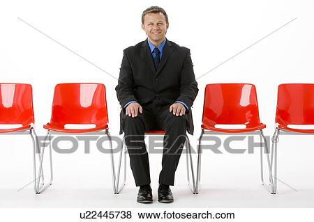 Stock Photo - Businessman Sitting In Row Of Empty Chairs . Fotosearch
