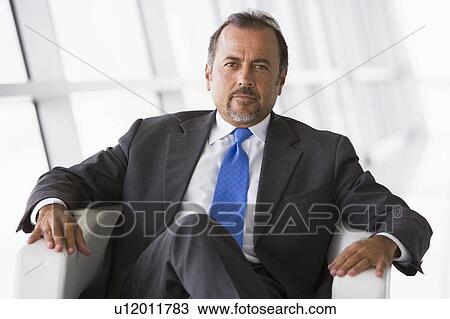 Businessman sitting indoors (high key/selective focus) View Large Photo Image Stock Image - Businessman sitting indoors (high key/selective focus). Fotosearch