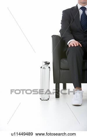 Stock Photo - Businessman Sitting Wearing Sneakers. Fotosearch