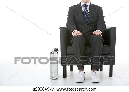Stock Photo - Businessman Sitting Wearing Sneakers. Fotosearch