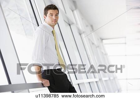 Businessman standing in corridor View Large Photo Image Stock Photography - Businessman standing in corridor. Fotosearch