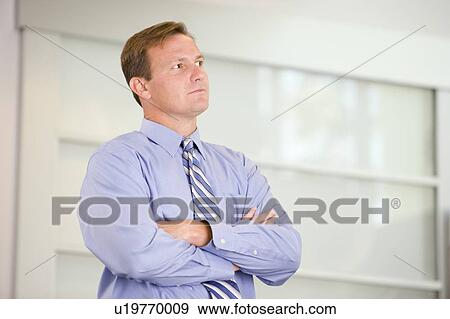Stock Photo - Businessman standing indoors. Fotosearch