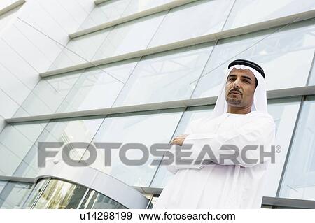 Businessman standing outdoors by building View Large Photo Image Stock Photo - Businessman standing outdoors by building. Fotosearch