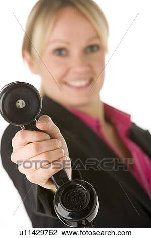 Stock Image - Businesswoman Holding Telephone Receiver. Fotosearch