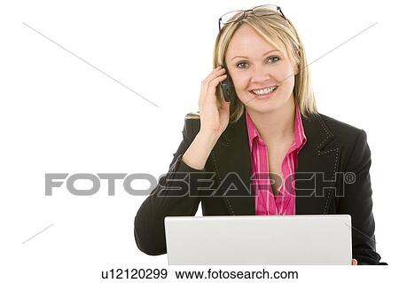 Stock Photo - Businesswoman Sitting In Front Of Laptop Talking On Mobile Phone . Fotosearch
